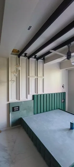 Bedroom with green headboard and ceiling beams