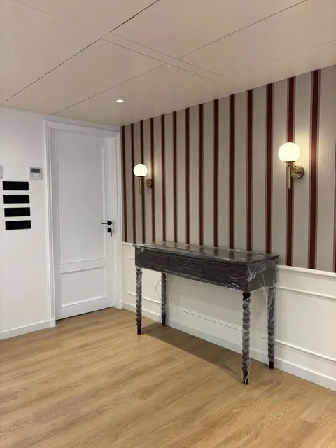 Foyer with striped wallpaper and wainscoting