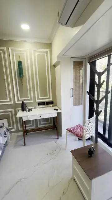 Bedroom with panelled wall and study desk